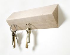 three keys hang on a wooden key holder