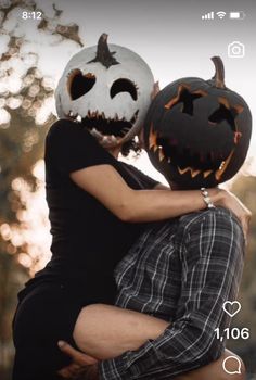 two people hugging each other with pumpkins on their heads and faces carved into them