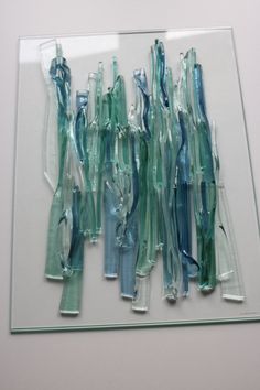 several toothbrushes are lined up on a clear glass plate with blue and green handles