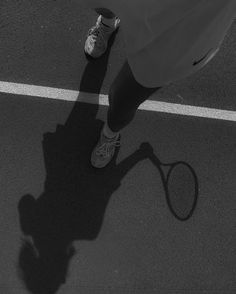 the shadow of a person holding a tennis racket