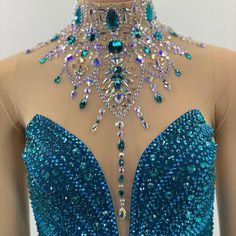 the back of a woman's blue dress with jewels on it