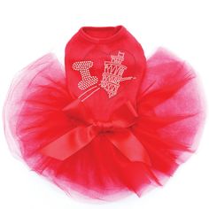 a dog wearing a red shirt and tutu skirt