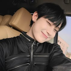 a young man sitting in the back seat of a car with his head turned to the side