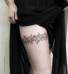 a woman's thigh with flowers and leaves on the bottom part of her leg