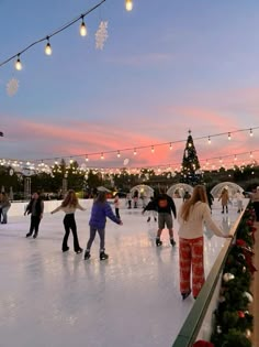 people skating on an ice rink at dusk