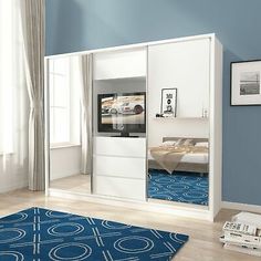 a bedroom with blue walls and white furniture