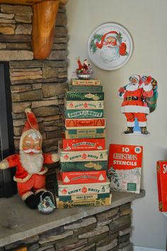 a stack of boxes sitting on top of a fireplace next to a santa clause figurine