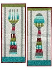 two quilted wall hangings with forks and spoons on each side, one is blue