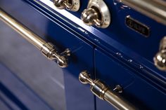 a blue stove with chrome handles and knobs