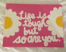 a pink sign with daisies on it that says life is tough, but someone you