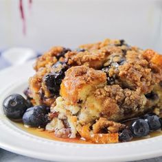 a close up of a plate of food with blueberries and crumbs on it