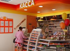 a woman standing in front of a store filled with food