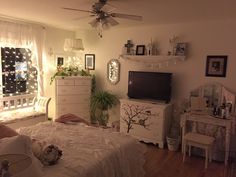 a bedroom with white furniture and lights on the ceiling