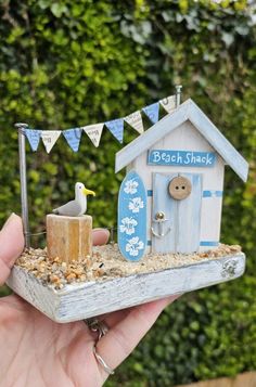 a miniature beach shack with a seagull sitting on it