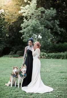 two women in wedding dresses standing with their dogs