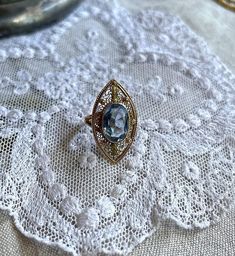 Featuring a gorgeous antique 1910s Edwardian Era solid 10k yellow gold decorative filigree statement ring adorned with a dazzling topaz blue marquee cut paste stone in a delicate bezel setting. Ring is approximately size 3.5 at 3.03 grams respectively and is stamped 10K on the inside of band.  This beauty is in excellent antique condition with paste stone intact with normal wear.  I have such an affinity for yellow gold blue together, this a beautifully crafted piece, ready to wear, size up and pass down for generations. Please feel free to contact me with any questions or suggestions I'm always learning  (Box not included) Art Deco Oval Filigree Jewelry, Oval Art Deco Filigree Jewelry, Vintage Gold Topaz Birthstone Ring, Oval Filigree Art Deco Jewelry, Vintage Marquise Gold Jewelry, Vintage Gold Marquise Jewelry, Victorian Yellow Gold Filigree Ring, Antique 14k Gold Filigree Ring Collectible, Antique Yellow Gold Filigree Ring With Gemstone