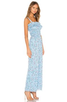 A Floral Fantasy: Embrace the beauty of spring with the Tularosa Ellie Jumpsuit in Carolina Blue Floral, a captivating piece adorned with a delicate wildflower print that gently speckles a rich aqua hue.Smocked Bodice for a Flattering Fit: The smocked bodice of this jumpsuit provides a comfortable and flattering fit, while the ruffle trim adds a touch of playful elegance.Versatile and Effortlessly Stylish: Whether you're strolling through a blooming garden or attending a special occasion, this v Floral Print Jumpsuits And Rompers For Garden Party, Elegant Light Blue Jumpsuits And Rompers For Summer, Feminine Sleeveless Jumpsuits For Spring, Fitted Floral Print Jumpsuits For Garden Party, Chic Floral Print Jumpsuits And Rompers For Spring, Chic Blue Jumpsuits And Rompers For Spring, Feminine Sleeveless Jumpsuits And Rompers For Spring, Fitted Floral Jumpsuits And Rompers For Garden Party, Blue Printed Jumpsuit For Spring