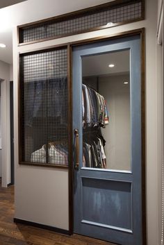 an open door leading to a closet with clothes on hangers