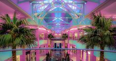 an indoor mall filled with palm trees and lights