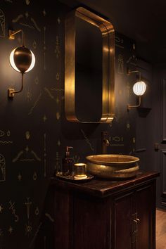 a bathroom with a sink, mirror and lights on the wall in it's dark room