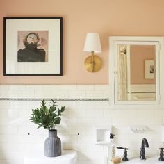 a bathroom with pink walls and white tile on the wall is featured in this article