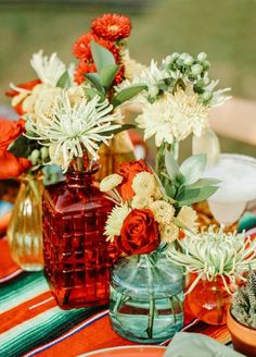 several vases filled with flowers sitting on top of a table