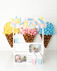 an ice cream stand with balloons and candy in it's cones on the wall