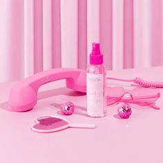 a pink phone, eyeglasses and hairdryer on a table