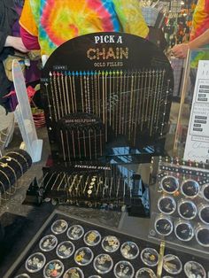 a display case filled with lots of different types of necklaces and jewelry on top of a table