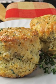 two biscuits on a white plate with herbs