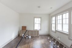 an empty room with wood floors and white walls