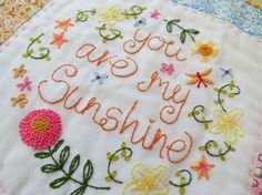 a close up of a piece of cloth with flowers on it and the words you are my sunshine