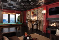 a living room filled with furniture and a pool table in front of a fire place