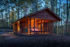 a small wooden cabin in the woods at night