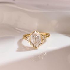 a diamond ring sitting on top of a white surface