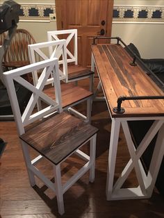 three wooden chairs sitting on top of a hard wood floor