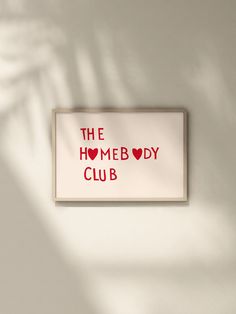 a sign that says the homeboy club hanging on a wall in front of a shadow