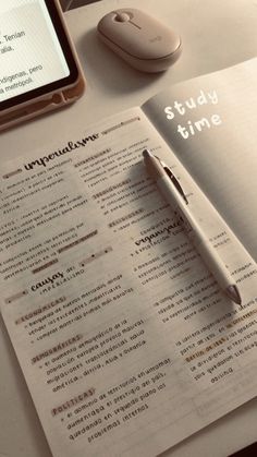 an open book on a table next to a computer mouse and cell phone with the text study time written in it