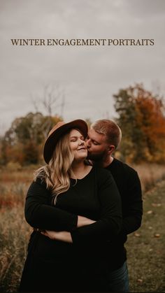 a man and woman embracing each other in an open field with the words winter engagement portraits above them