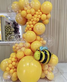 a bunch of balloons that are in the shape of a bee sitting on top of each other