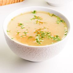 a white bowl filled with broccoli soup on top of a table