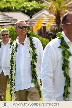 a group of men standing next to each other wearing leis and flower garlands