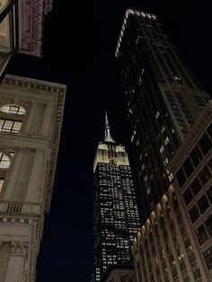 looking up at the top of two skyscrapers in new york city, ny lit up at night