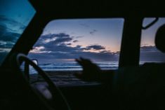 the view from inside a vehicle looking out at the ocean and clouds in the sky