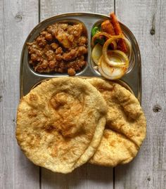 a metal tray filled with food on top of a wooden table