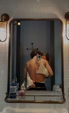 a man is taking a selfie in front of a mirror with his back turned to the camera