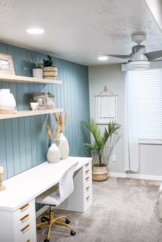 a bedroom with blue walls and white furniture