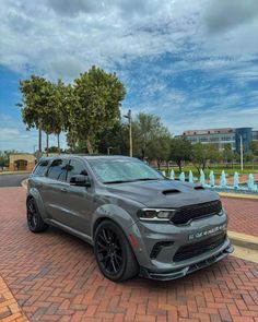 a grey dodge duran parked in front of a fountain