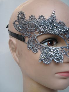 * This stiff silver lace half mask has been designed with five pointed silver beaded stars which have been trimmed and stationed around each eye. Down the front of the mask four faceted crystals accent the shape of the nose. * To secure the mask there are two black satin ribbons on each side to be tied in the back. * A great piece for a Masked Ball, a Night at the Opera, Class Reunion, Birthday Celebration, Halloween, New Year's Celebrations, Parade or Festival, Costume party or Play, Carnivale, Elegant Silver Evening Masks, Gothic Silver Masquerade Mask For Party, Silver Rhinestone Eye Mask For Masquerade, Silver Rhinestone Eye Masquerade Mask, Silver Rhinestone Masquerade Mask For Carnival, Silver Gothic Masquerade Mask For Carnival, Elegant Silver Masks And Prosthetics For Party, Elegant Silver Eye Mask, Silver Masks For Costume Party