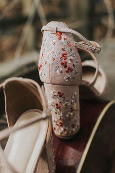 a pair of women's shoes sitting on top of a wooden table next to each other